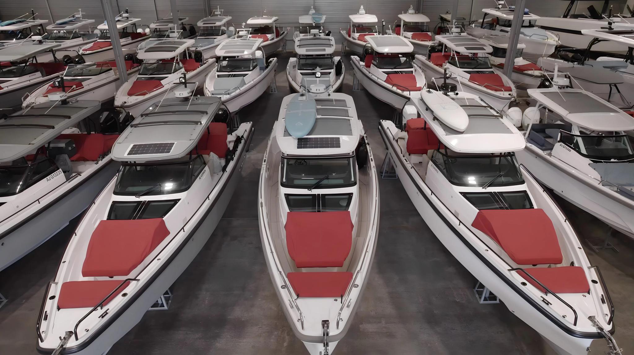 Flotte de bateaux de plaisance blancs et rouges alignés dans un hangar de stockage