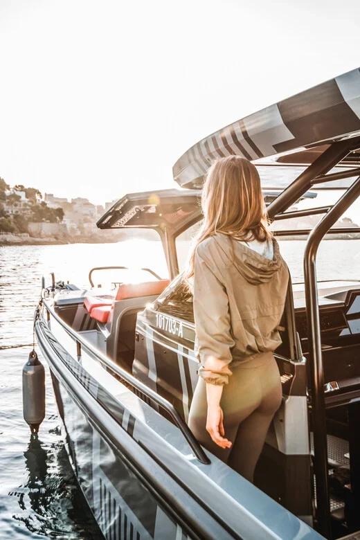 Femme à bord d'un luxueux bateau Brabus Marine au coucher de soleil