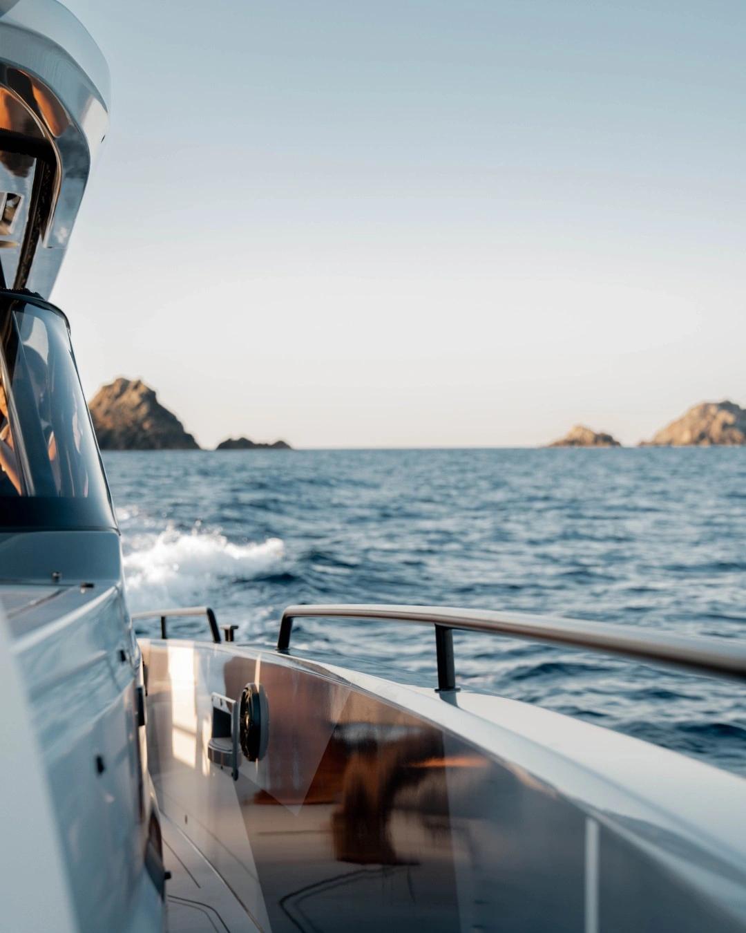 Bateau d'occasion naviguant en mer avec des îles rocheuses à l'horizon par beau temps