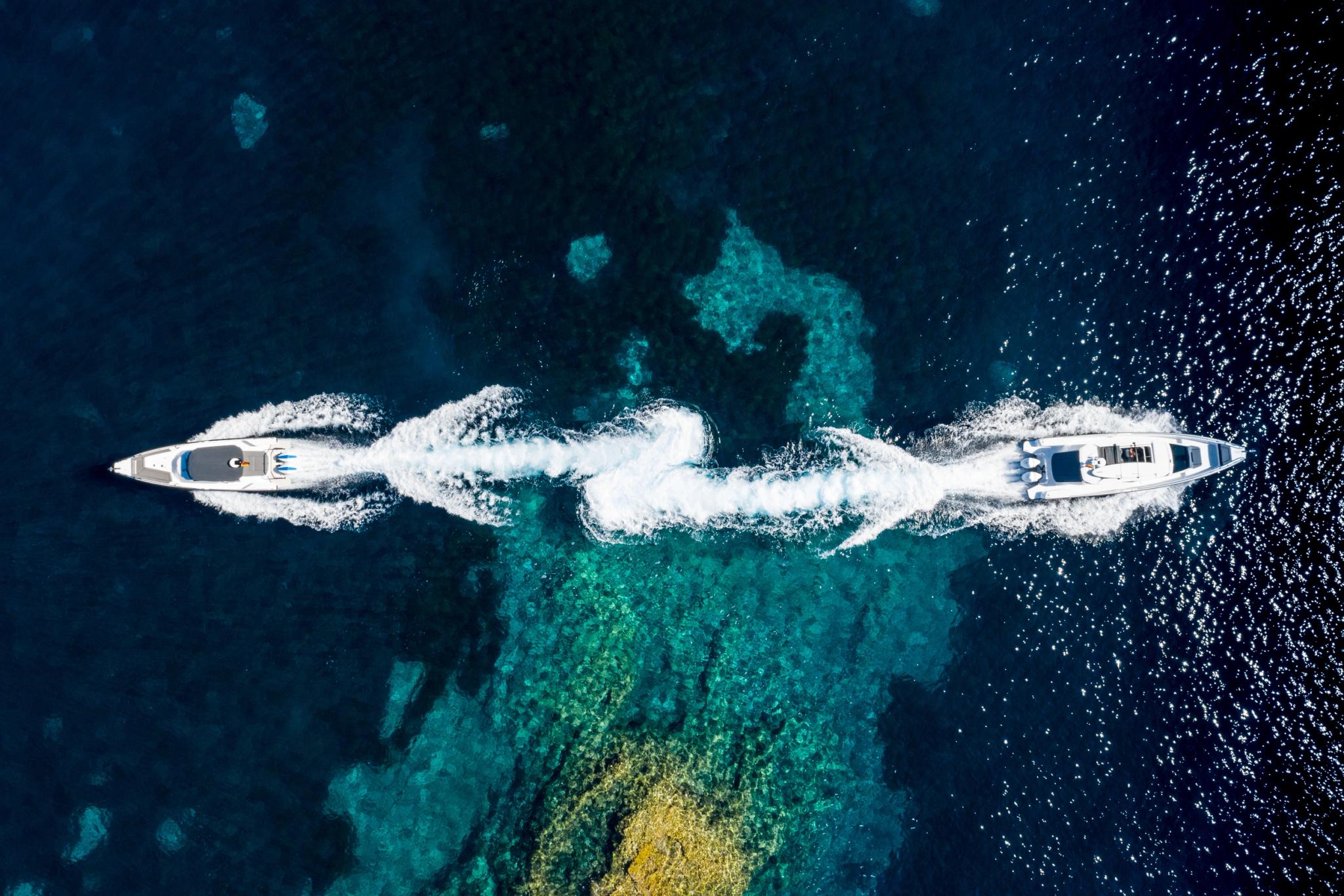 Vue aérienne de deux bateaux neufs naviguant côte à côte sur une mer turquoise