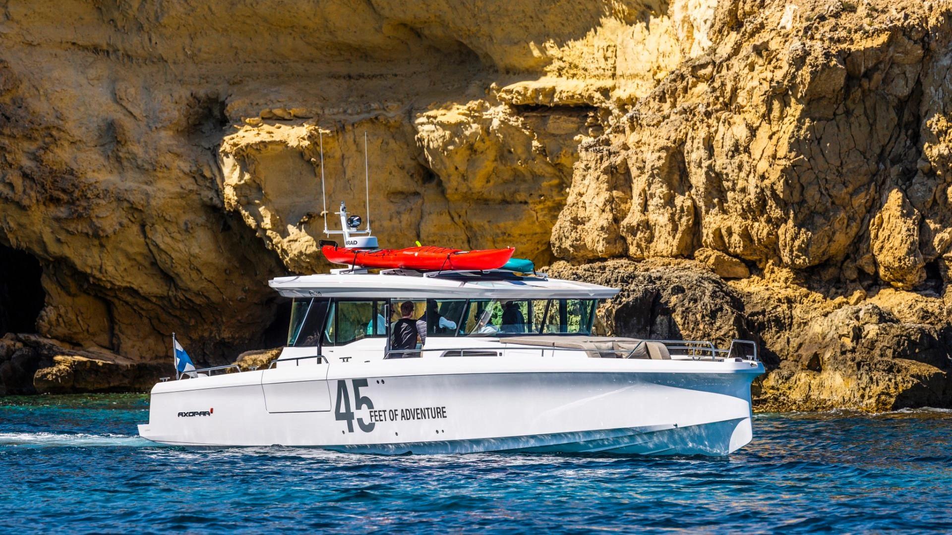 Bateau de location "Feet of Adventure" naviguant près des falaises rocheuses méditerranéennes