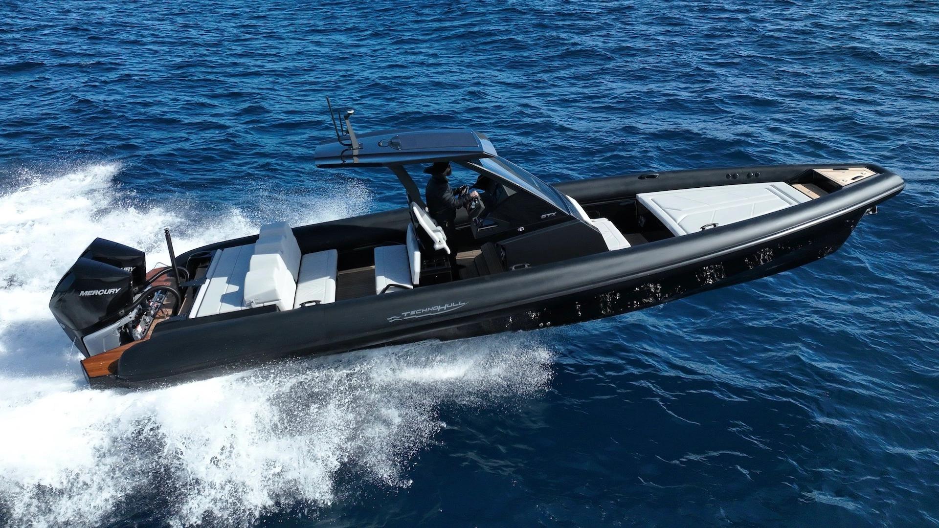 Bateau de luxe Technohull noir et blanc naviguant sur les vagues de la mer bleue